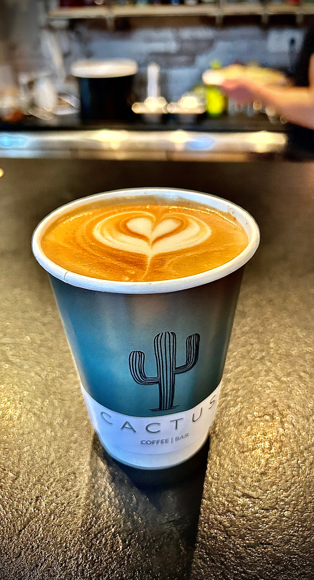 Latte art καρδιά σε branded ποτήρι του Cactus Coffee Bar
